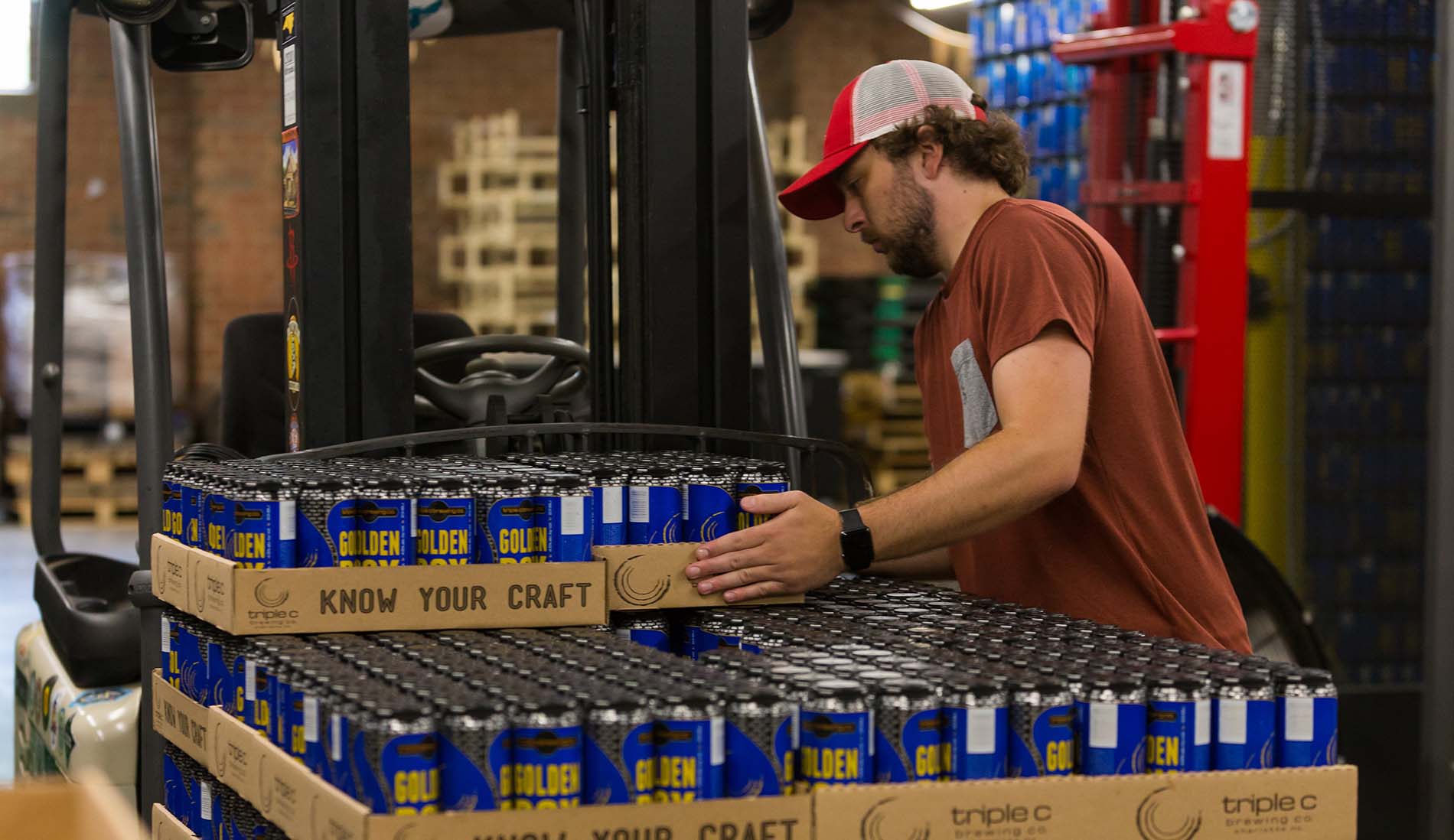 brewery employee stacking beer