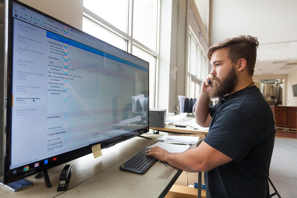 brewery employee standing at computer