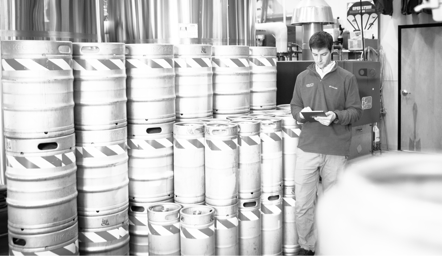 brewery employee checking kegs with ekos software