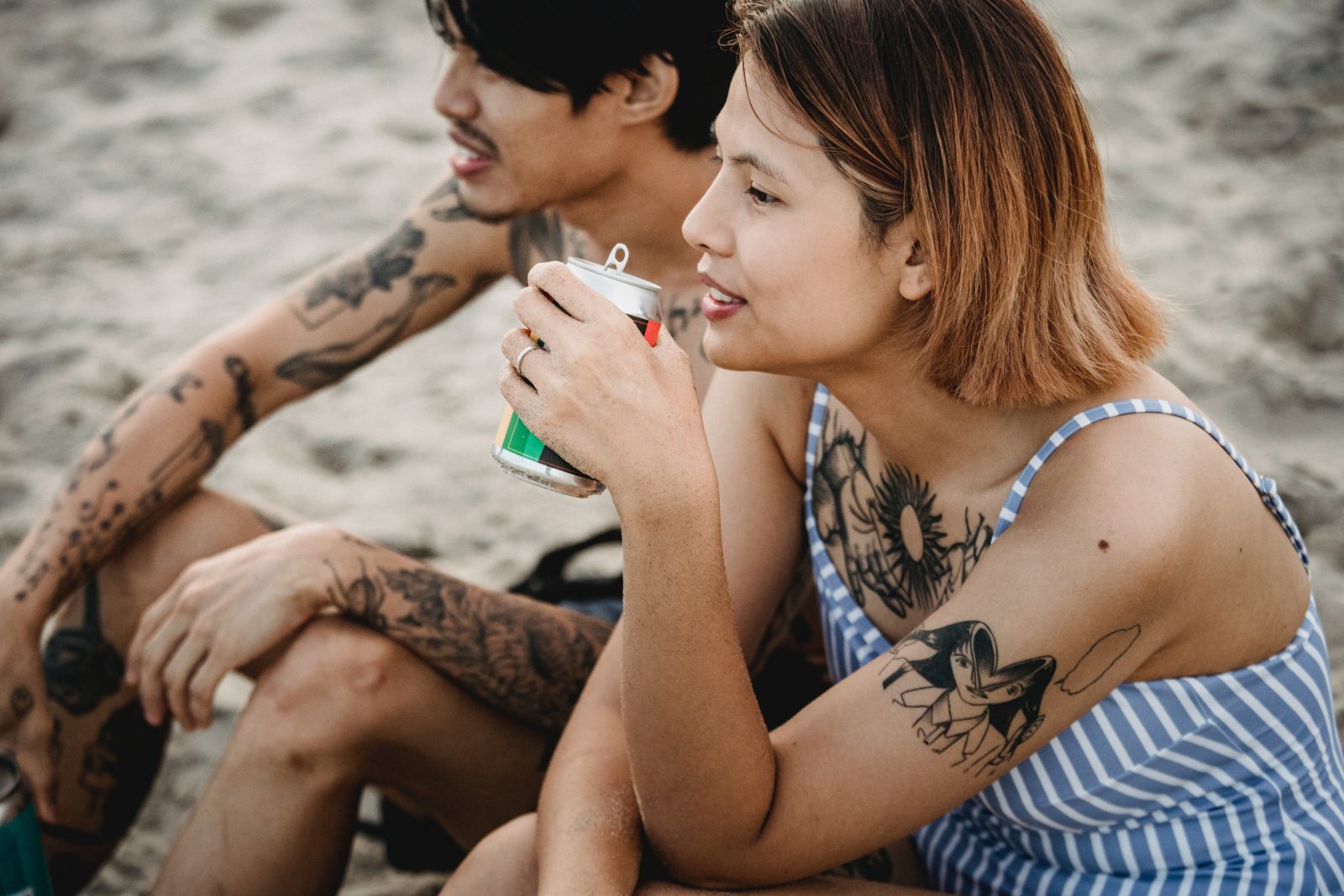 Young people drinking canned wine on the beach. Alternative wine packaging types can be more appealing to younger demographics.
