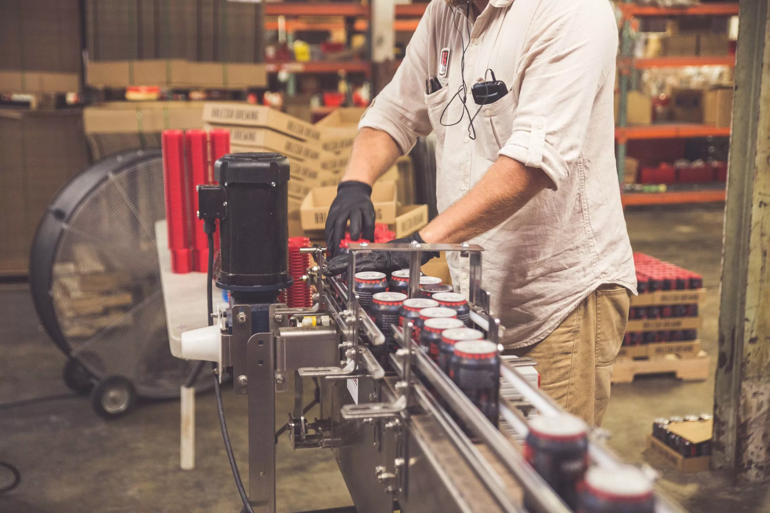brewery employee using a canning line